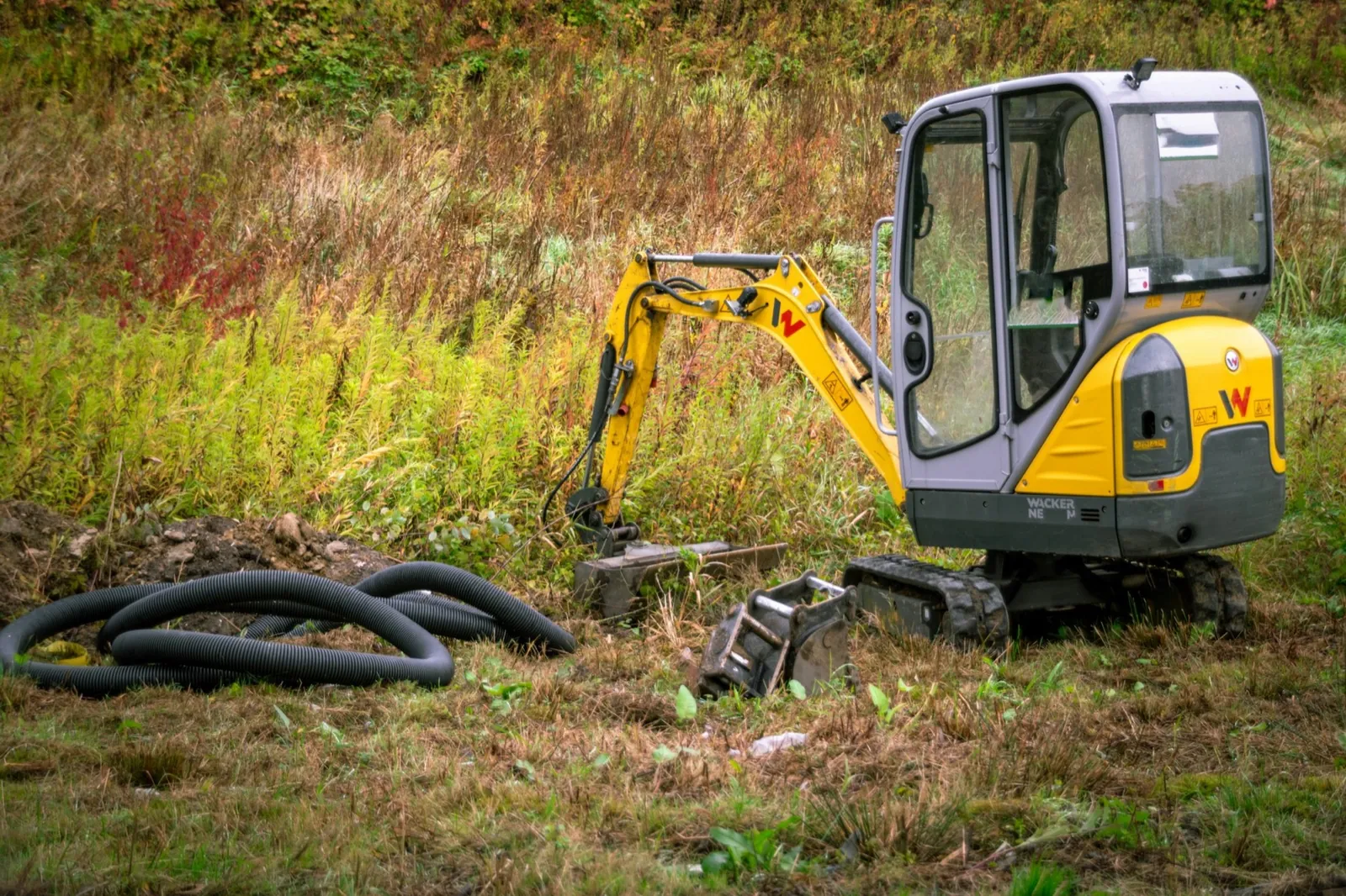Excavator și conducte pregătite pentru rețea de canalizare